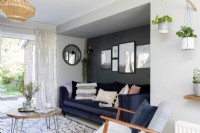 Modern living room with blue velvet sofa and dark grey accent wall