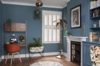 Colourful sitting room with blue painted walls and shutters
