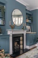 Classic victorian fireplace in bold blue sitting room