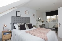 Loft bedroom with grey headboard and pink knitted throw