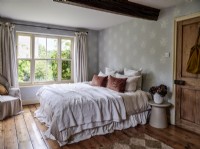 Neutral bedroom with exposed beam and wooden floorboards
