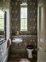 Bathroom with floral wallpaper and stone floor