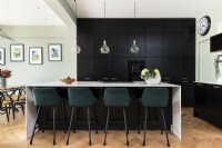 Contemporary kitchen with tall black wall units and island.