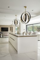 Contemporary kitchen with large pendants over marble island.