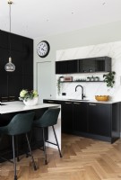 Contemporary large kitchen with black wall cupboards and island.