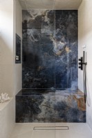 Wet room with large blue marble tiles. 