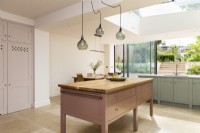 Classic contemporary kitchen with large freestanding pink kitchen island.