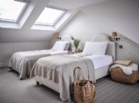 Neutral loft conversion twin bedroom with skylights