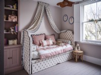 Upholstered daybed with canopy drapes