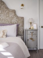 Bed with patterned headboard and bedside table