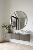 Floating console unit with large round mirror in a modern living room